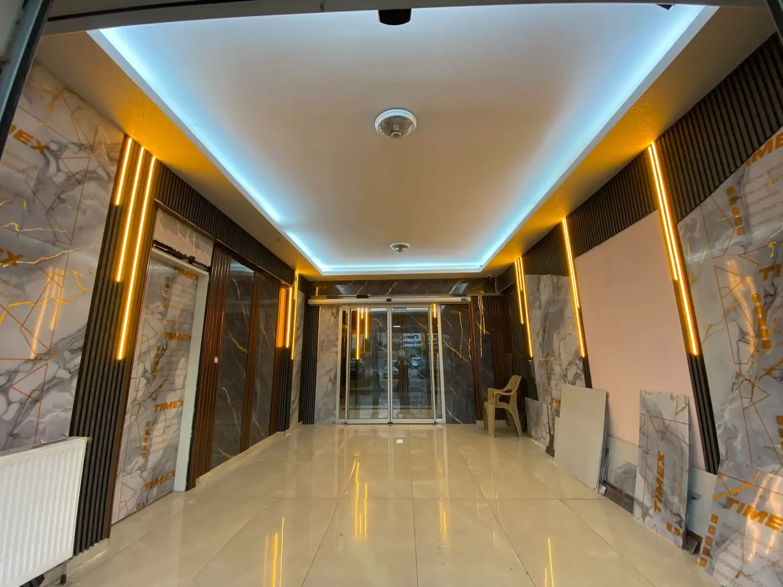 Mermer kaplı apartman girişinde gizli LED tavan ve dikey LED profil aydınlatması